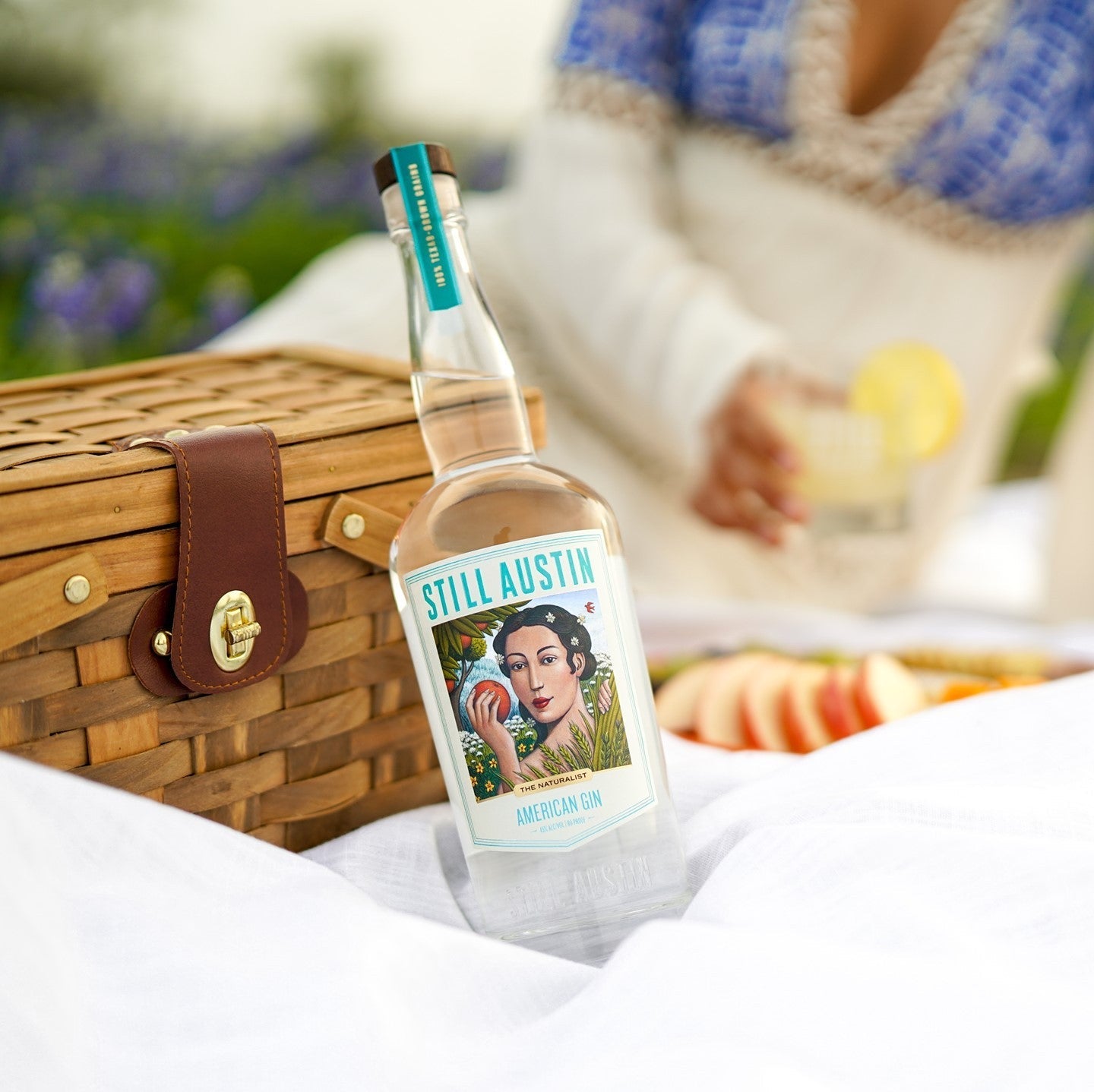 Still Austin American Gin "The Naturalist sitting on a white blanket at a picnic