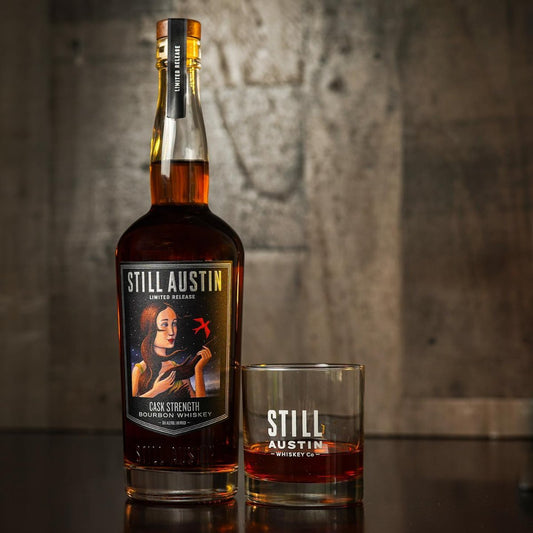 Still Austin Cask Strength Bourbon on a table with a glass with whiskey